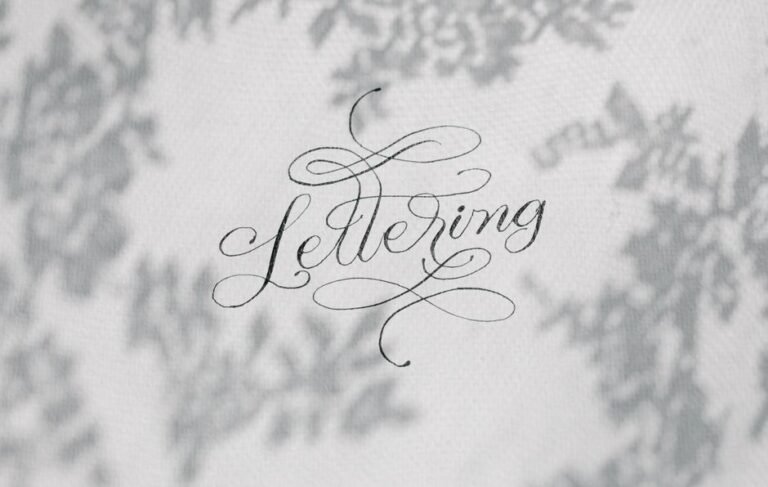 Stylish handwritten lettering on a textured surface with artistic shadows.