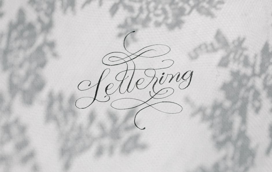 Stylish handwritten lettering on a textured surface with artistic shadows.