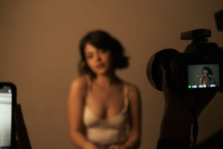 Blurred portrait of a woman in a studio with cameras capturing her image.