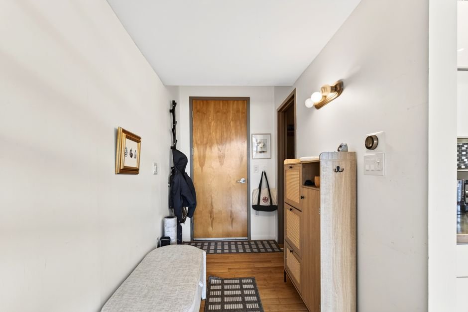 Contemporary entry hallway in Boston apartment showcasing modern industrial decor and wooden accents.