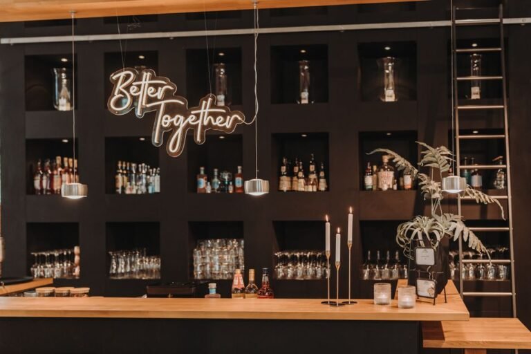 Stylish bar interior featuring a 'Better Together' sign, shelves of bottles, and glasses.