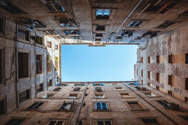 A striking view of an inner courtyard and sky framed by residential buildings.