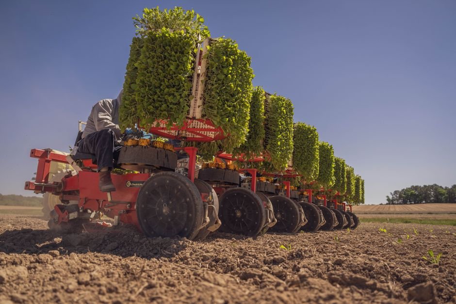 Modern agricultural equipment used for efficient field planting on a sunny day.