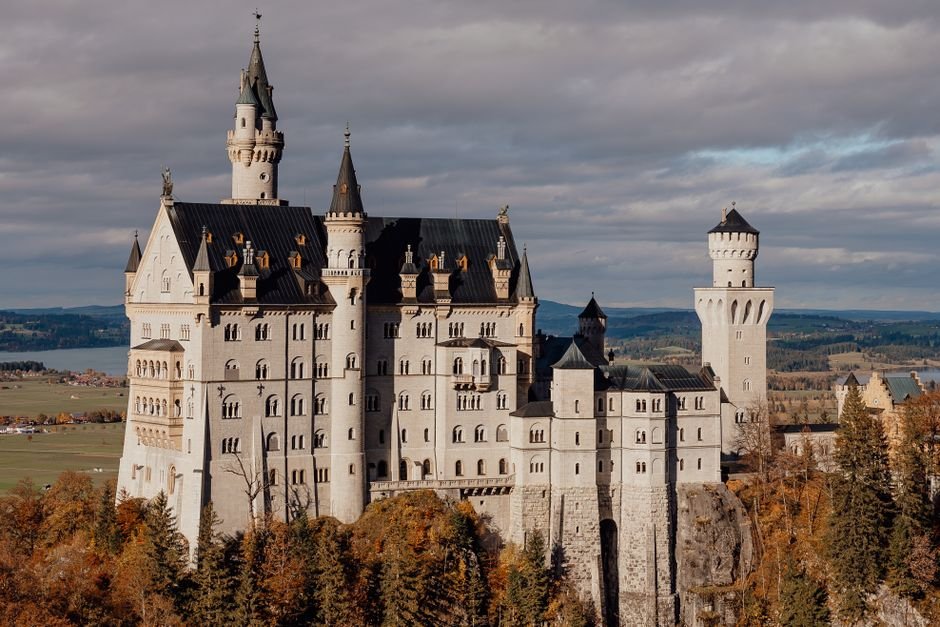 Stunning view of Neuschwanstein Castle in Schwangau, Bavaria, framed by vibrant autumn foliage.